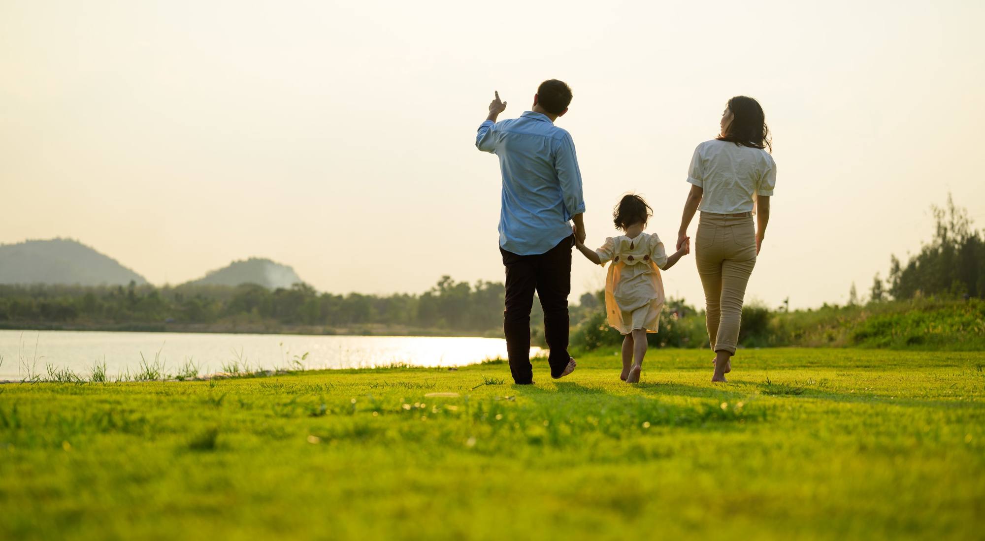 Family walking together by the water at sunset